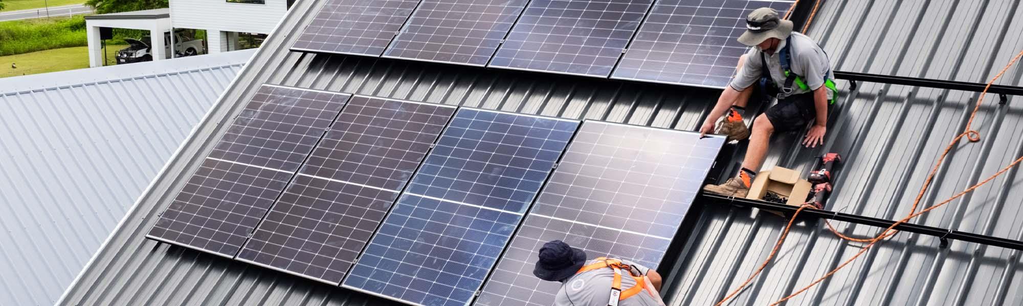 two workers installing solar panels