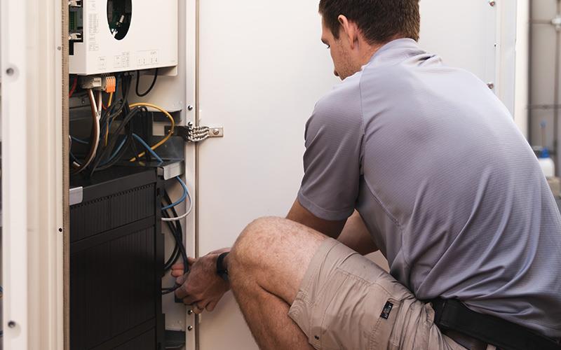 man installing solar batteries